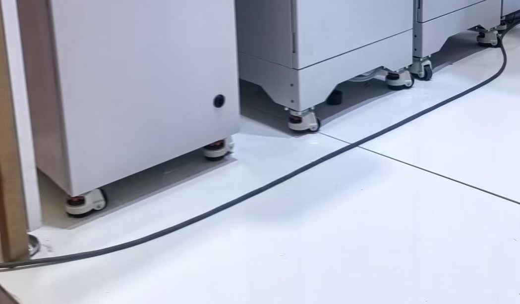 Leveling casters fitted to a production equipment cabinet base